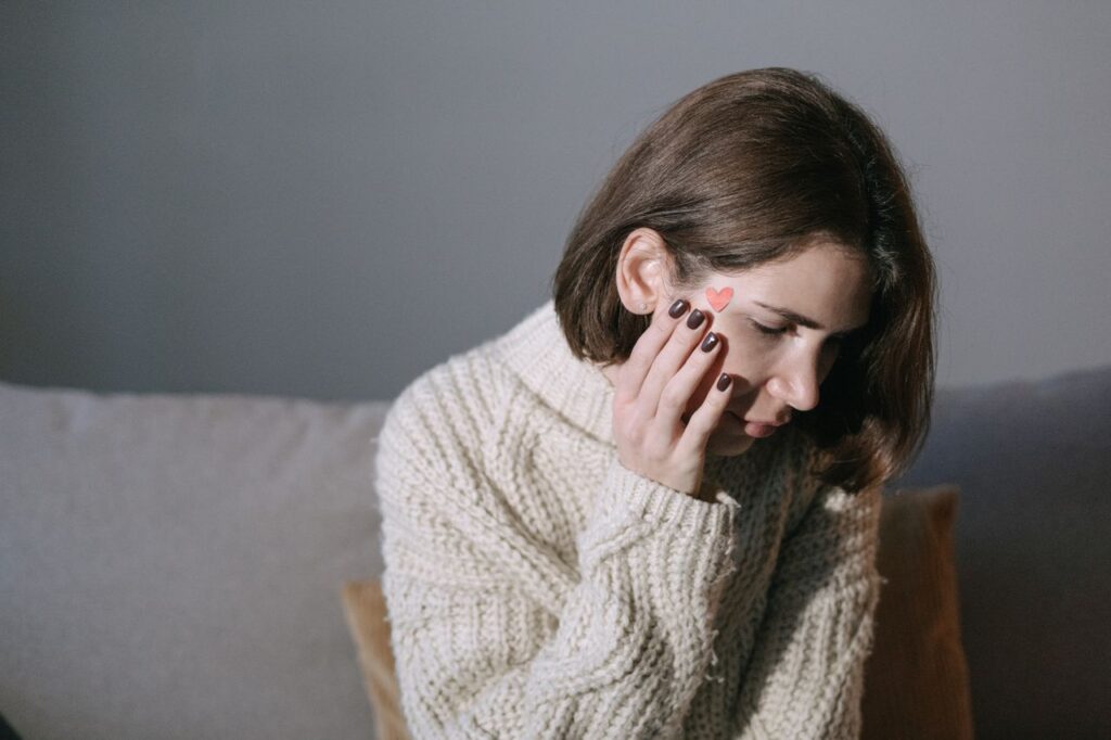 Emotionally overwhelmed woman sitting alone after leaving a trauma-bonded relationship