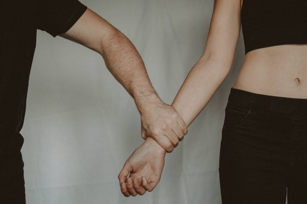 Couple holding hands in a trauma-bonded relationship showing emotional attachment despite pain