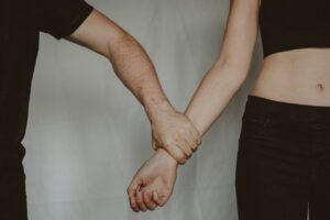 Couple holding hands in a trauma-bonded relationship showing emotional attachment despite pain